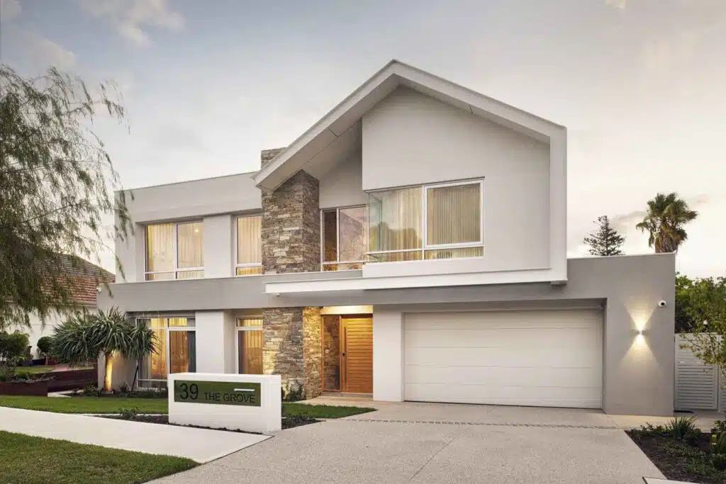 A beautifully designed two-story home with stone cladding, large windows, and modern landscaping.